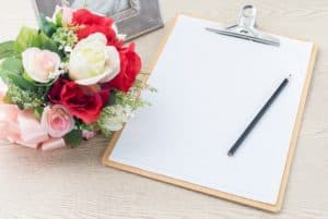 Flowers next to a notepad.