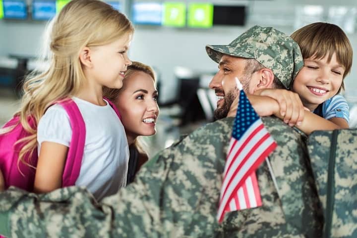 Family greeting military father home from duty.